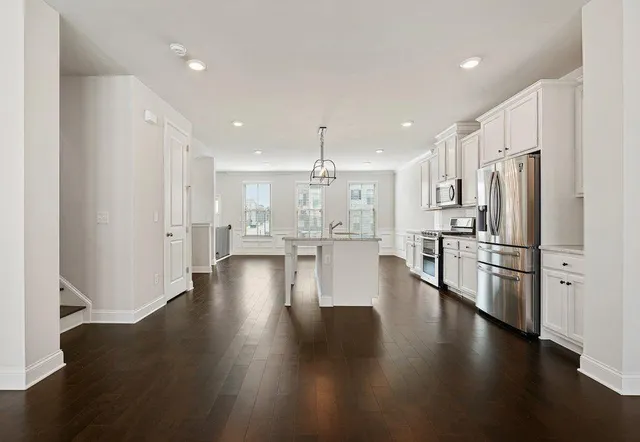 a view of kitchen with refrigerator stove and wooden floor