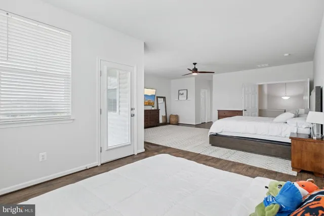 a bedroom with a bed lamp and a large window