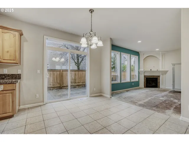 a view of an empty room with a fireplace and a window
