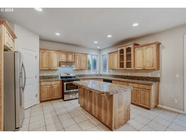 a kitchen with stainless steel appliances granite countertop a stove a sink dishwasher a refrigerator and a oven