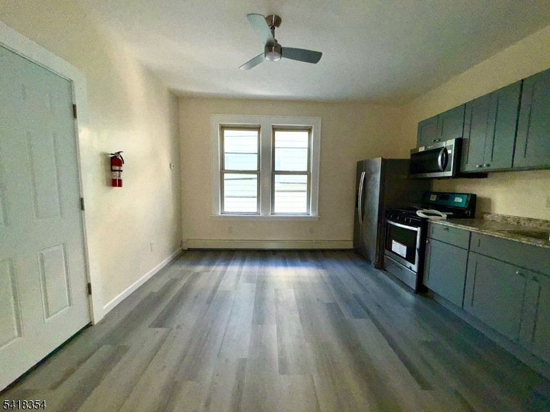 37-39 Field Place, Unit 2R Newark, NJ 07112 - Photo 6 of 10 a kitchen with granite countertop wooden floors a sink and appliances