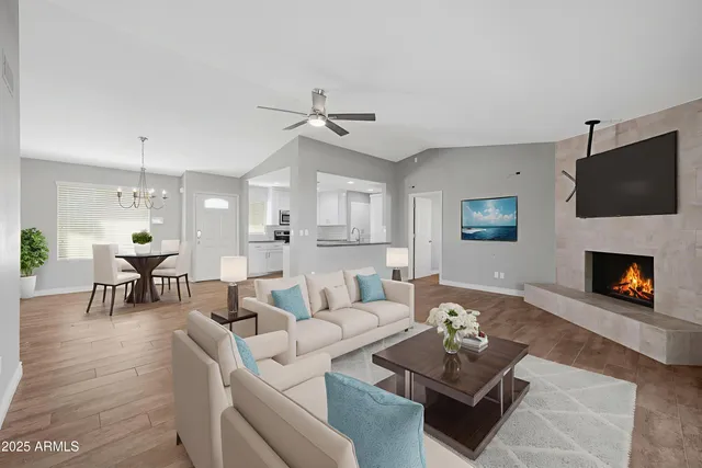 a living room with furniture a flat screen tv and a fireplace