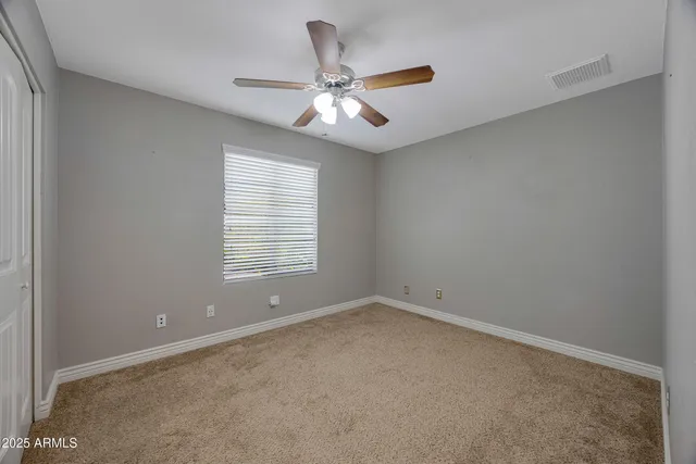 an empty room with a window and a fan