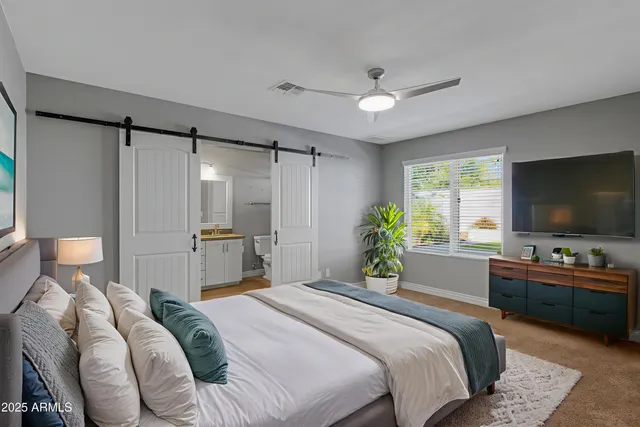 a bedroom with a bed and a flat screen tv