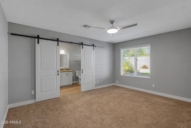 a view of empty room with window and ceiling fan