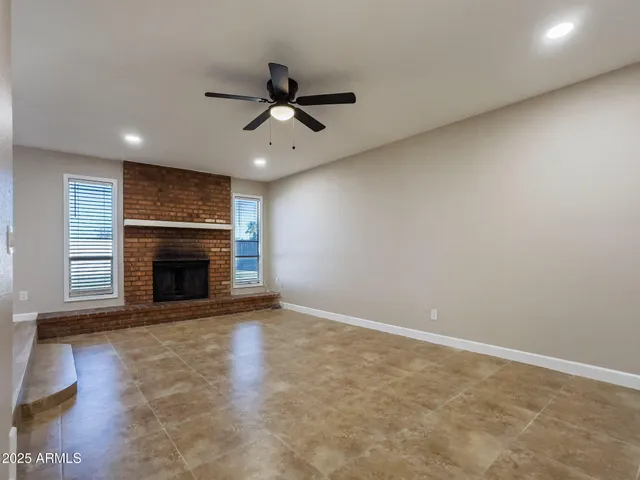 a view of an empty room with a fireplace and a window