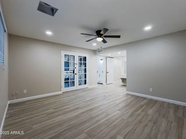 a view of an empty room with a window and a kitchen