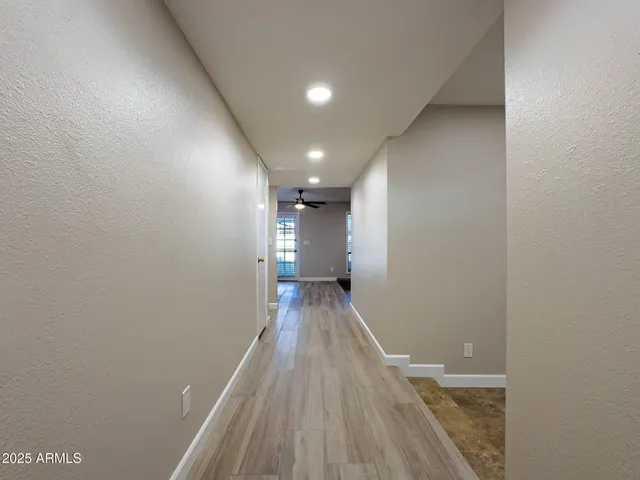 a view of a hallway with wooden floor