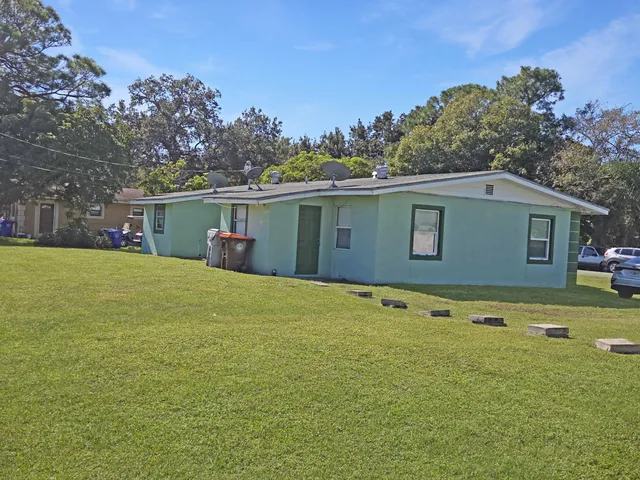a backyard of a house with table and chairs
