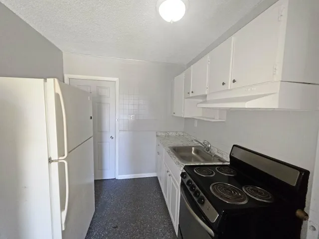 a kitchen with a refrigerator and a stove