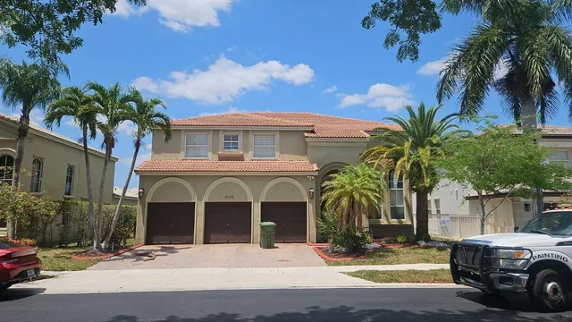 a view of a house with a yard and palm trees