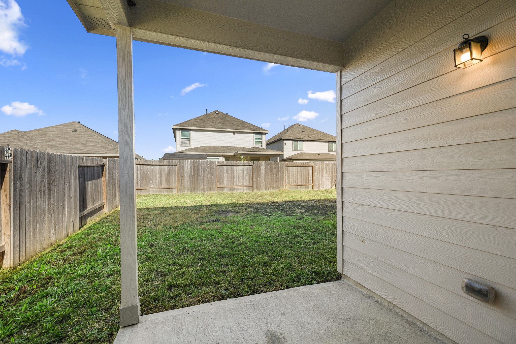 3571 Cannon Drive Conroe, TX 77301 - Photo 25 of 39 Your covered patio area opening to a fenced backyard with a well-maintained lawn, ideal for outdoor relaxation and privacy.