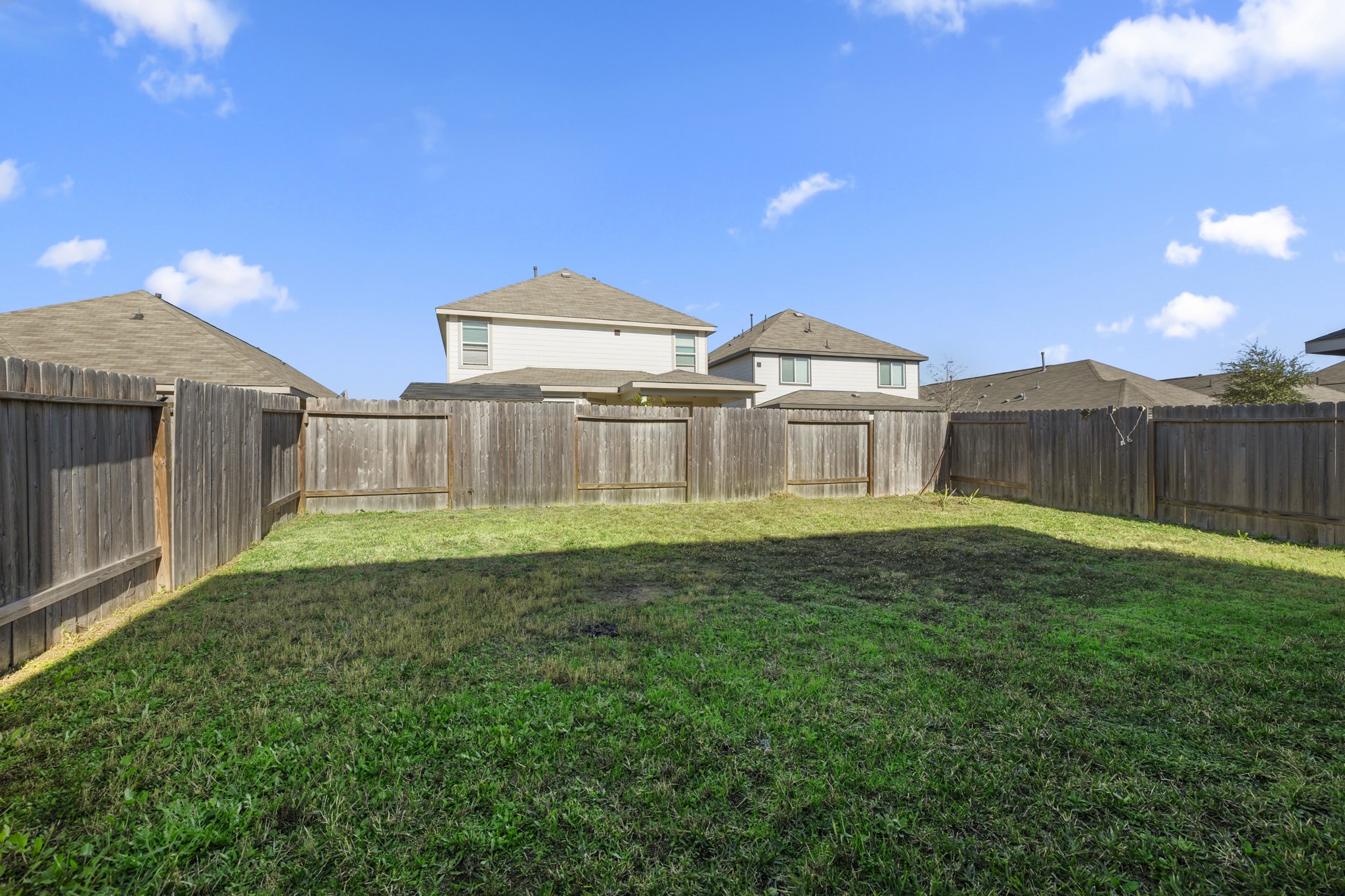 3571 Cannon Drive Conroe, TX 77301 - Photo 26 of 39 Spacious fenced backyard with well-maintained grass, ideal for outdoor activities and privacy.