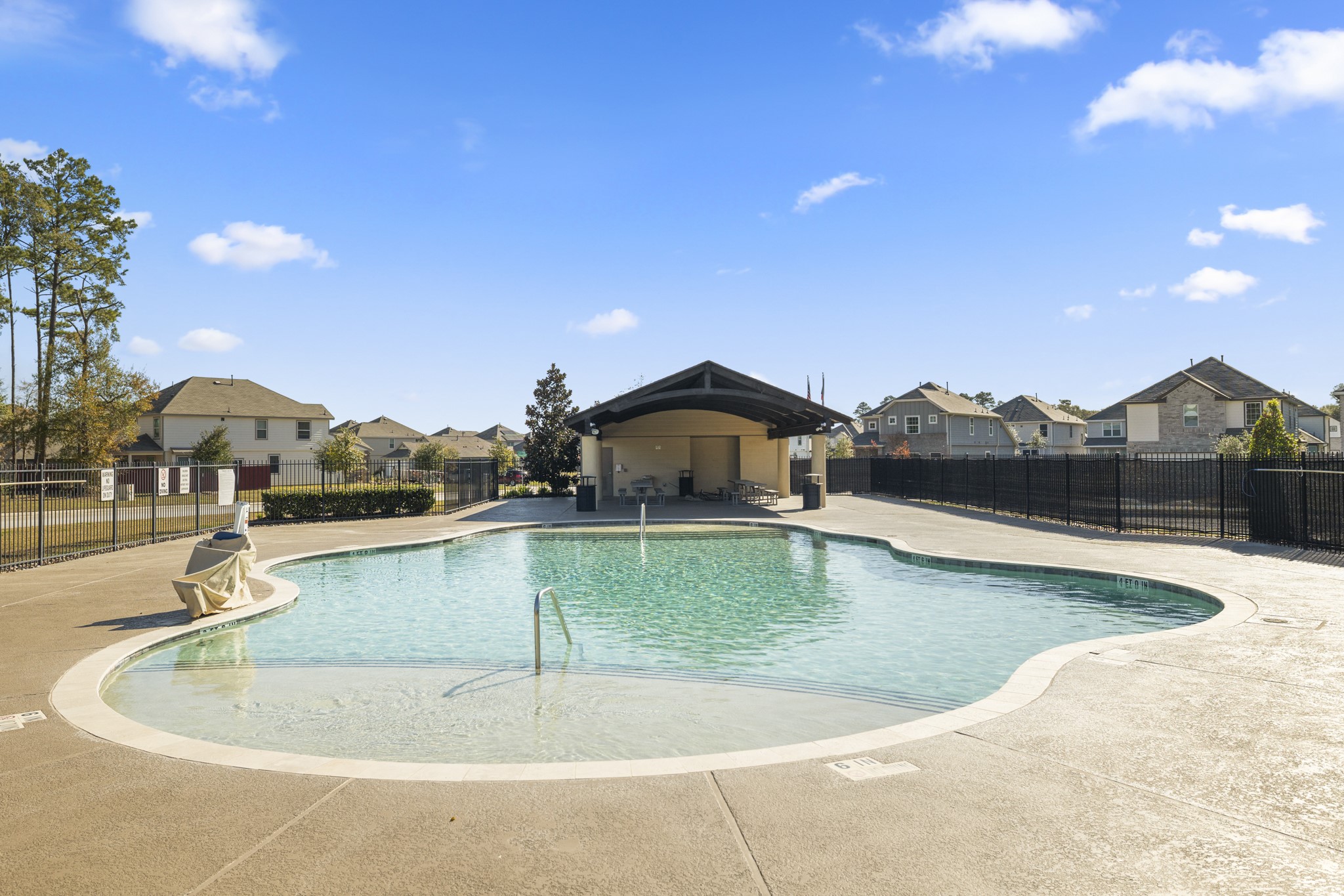 3571 Cannon Drive Conroe, TX 77301 - Photo 30 of 39 Community pool with a covered seating area, surrounded by a secure fence and nearby homes, perfect for relaxing and social gatherings.