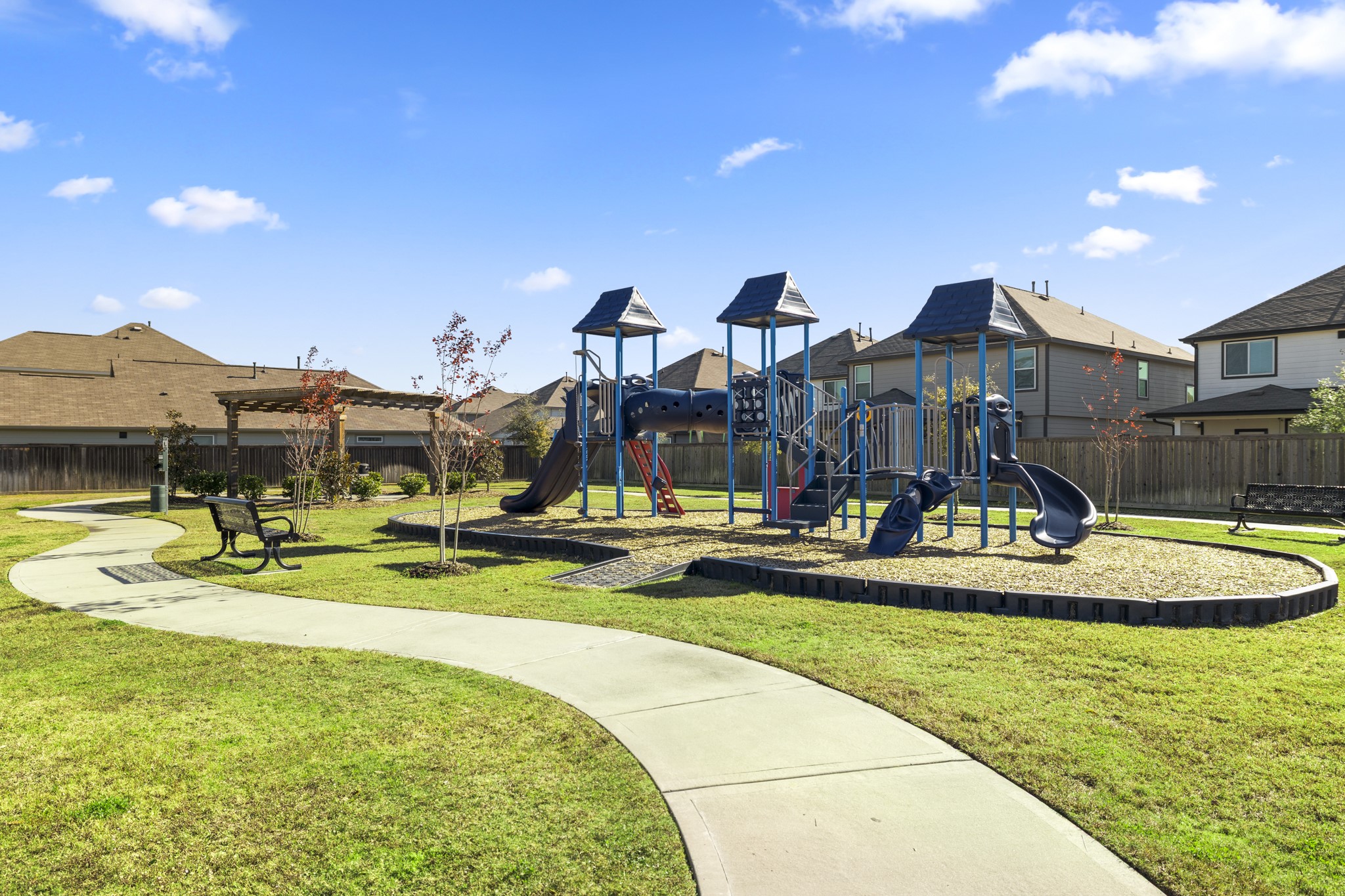 3571 Cannon Drive Conroe, TX 77301 - Photo 32 of 39 Enjoy a well-maintained playground in a residential neighborhood, featuring modern play structures, a walking path, and benches, surrounded by houses. Ideal for families with children.