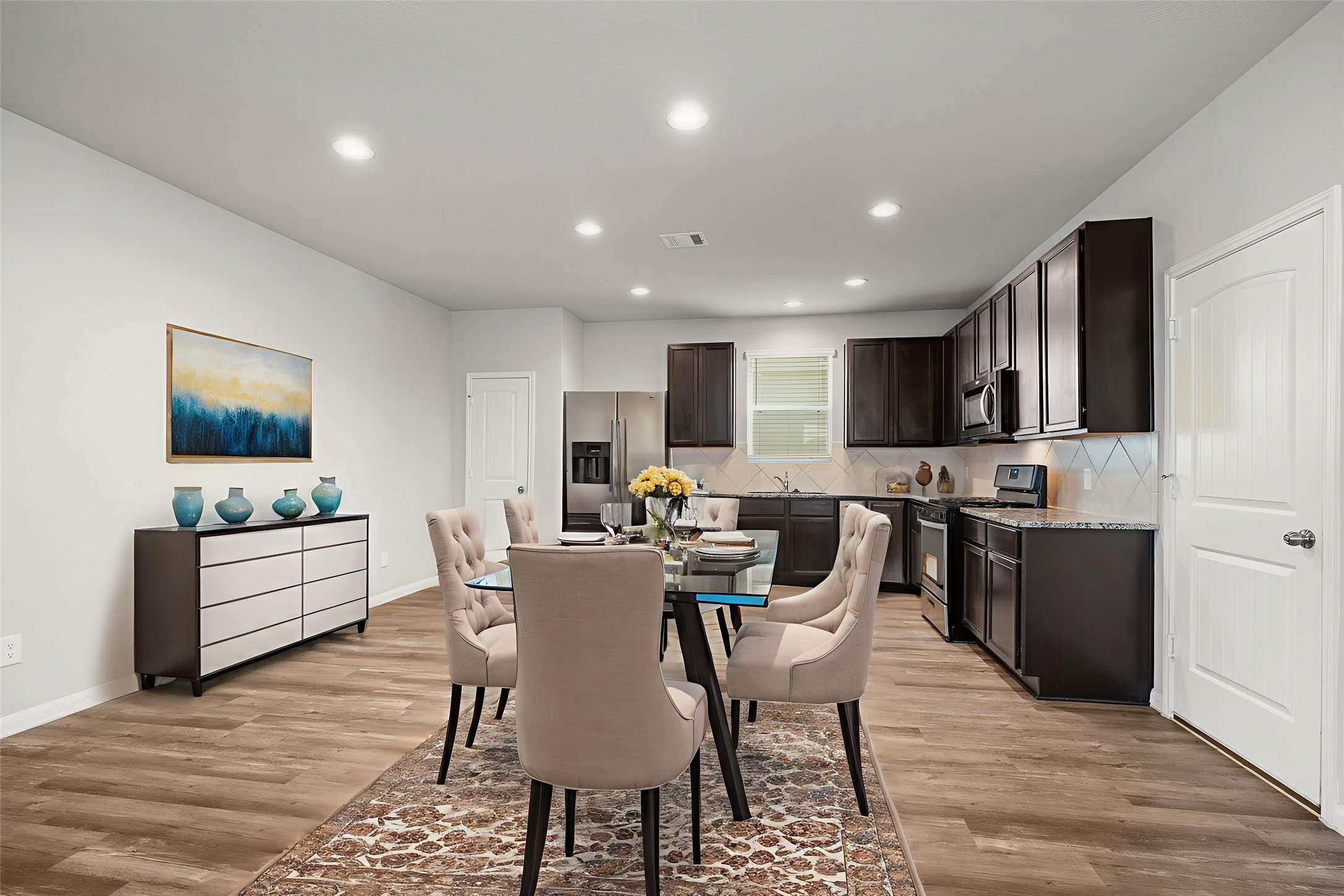 3571 Cannon Drive Conroe, TX 77301 - Photo 6 of 39 This photo showcases a spacious, modern kitchen with dark cabinets, stainless steel appliances, and hardwood flooring. The open layout offers ample space for dining and entertaining. *Virtually staged*