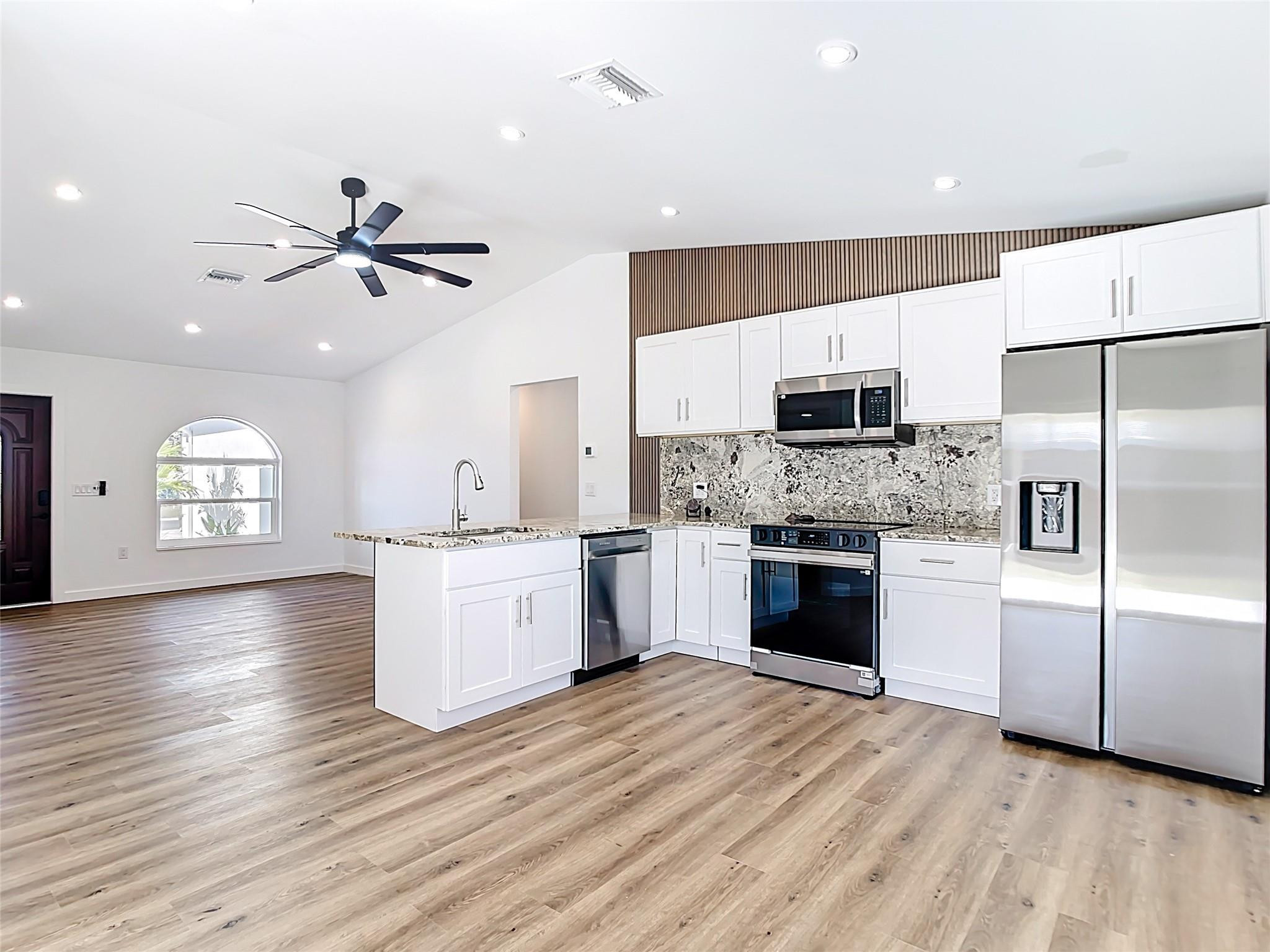 2565 Englewood Road Venice, FL 34293 - Photo 4 of 19 a large kitchen with a refrigerator and a stove top oven