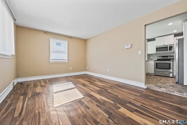 a view of a kitchen with wooden floor and electronic appliances