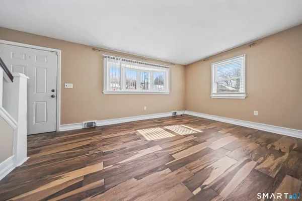 a view of a room with wooden floor and window