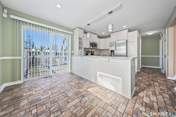 a kitchen with stainless steel appliances kitchen island granite countertop a refrigerator oven a sink and dishwasher