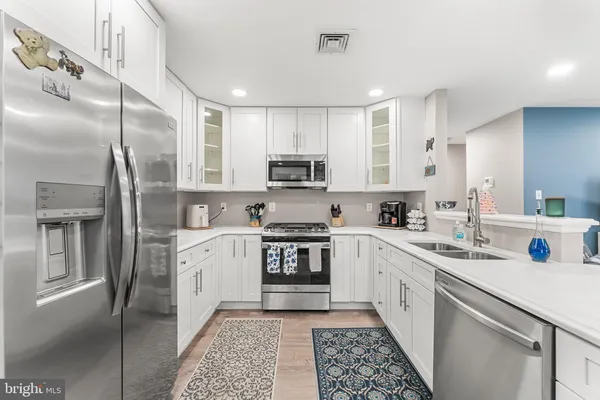 a kitchen with a sink stainless steel appliances and cabinets