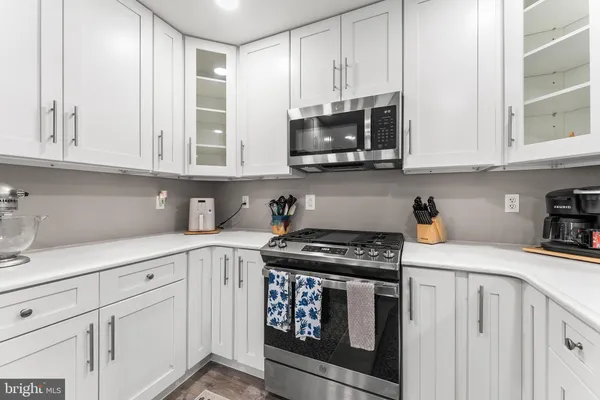 a kitchen with white cabinets and appliances
