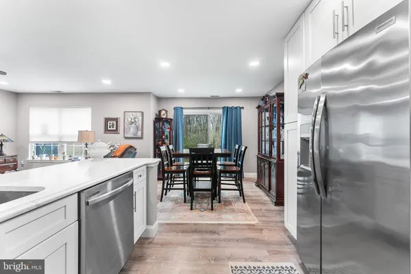 a kitchen with stainless steel appliances kitchen island granite countertop a refrigerator a table and chairs