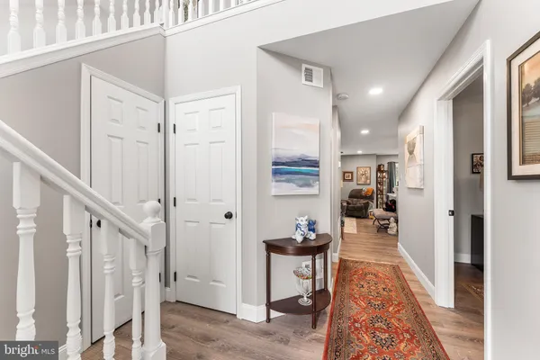 a view of a hallway with wooden floor and furniture