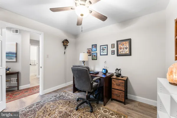 a view of a workspace with furniture and a window