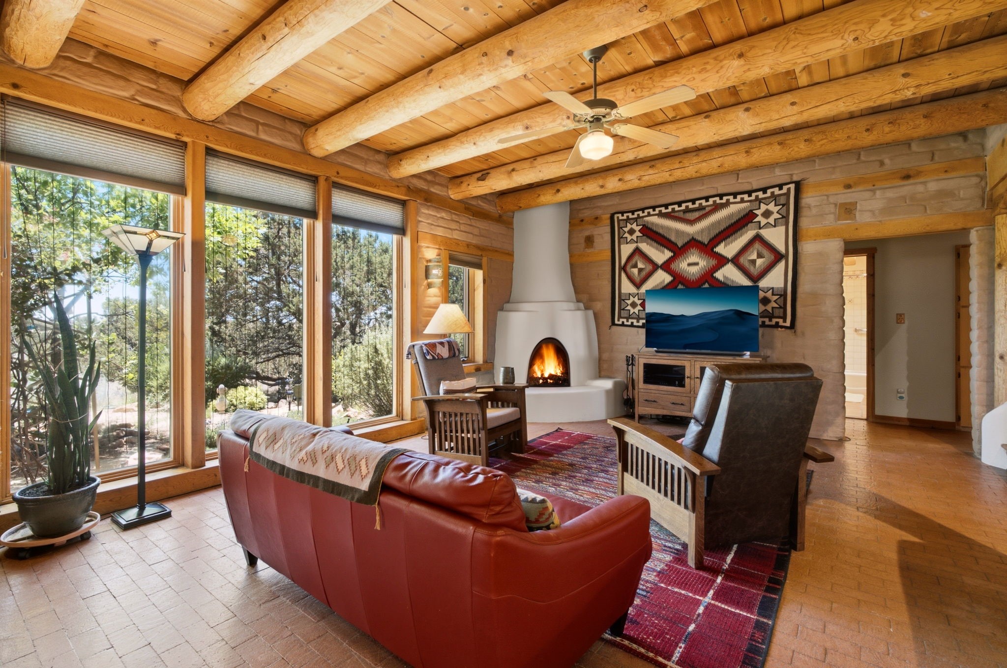 22 Mimosa Road Santa Fe, NM 87508 - Photo 2 of 51 Exposed adobe walls in living room, vigas, kiva fireplace and brick floors