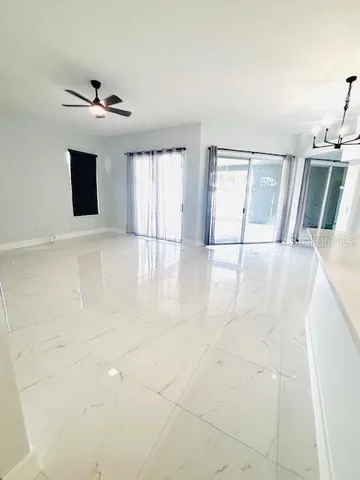 an empty room with windows and fireplace