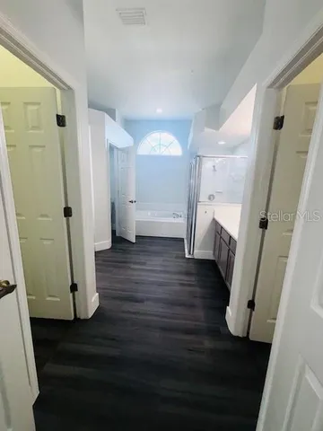 a view of a hallway with wooden floor and staircase