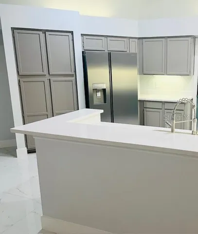 a view of a kitchen with wooden cabinet and refrigerator
