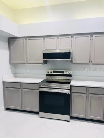 a kitchen with granite countertop white cabinets and black appliances