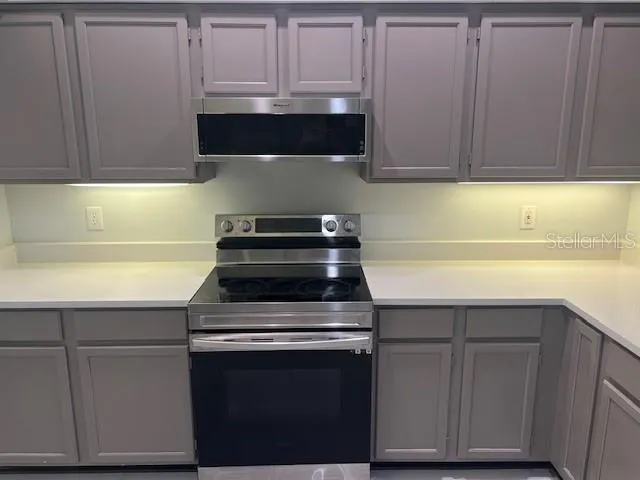 a kitchen with granite countertop cabinets and white stove
