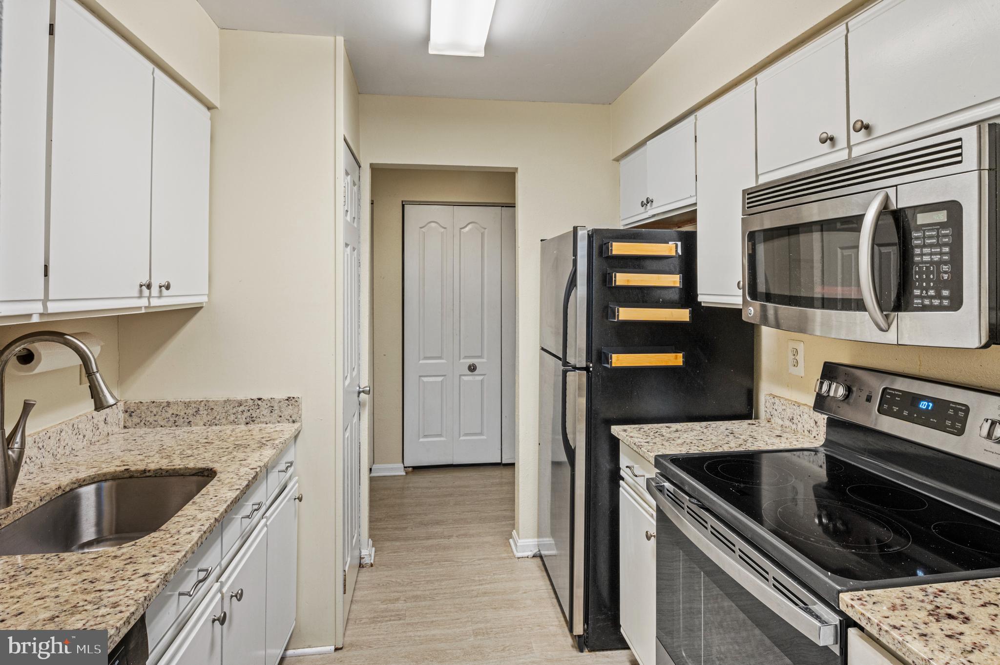 8559 Falls Run Road, Unit L Ellicott City, MD 21043 - Photo 5 of 28 a kitchen with granite countertop a sink and stainless steel appliances