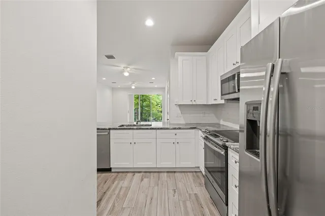 a kitchen with a refrigerator a sink and cabinets