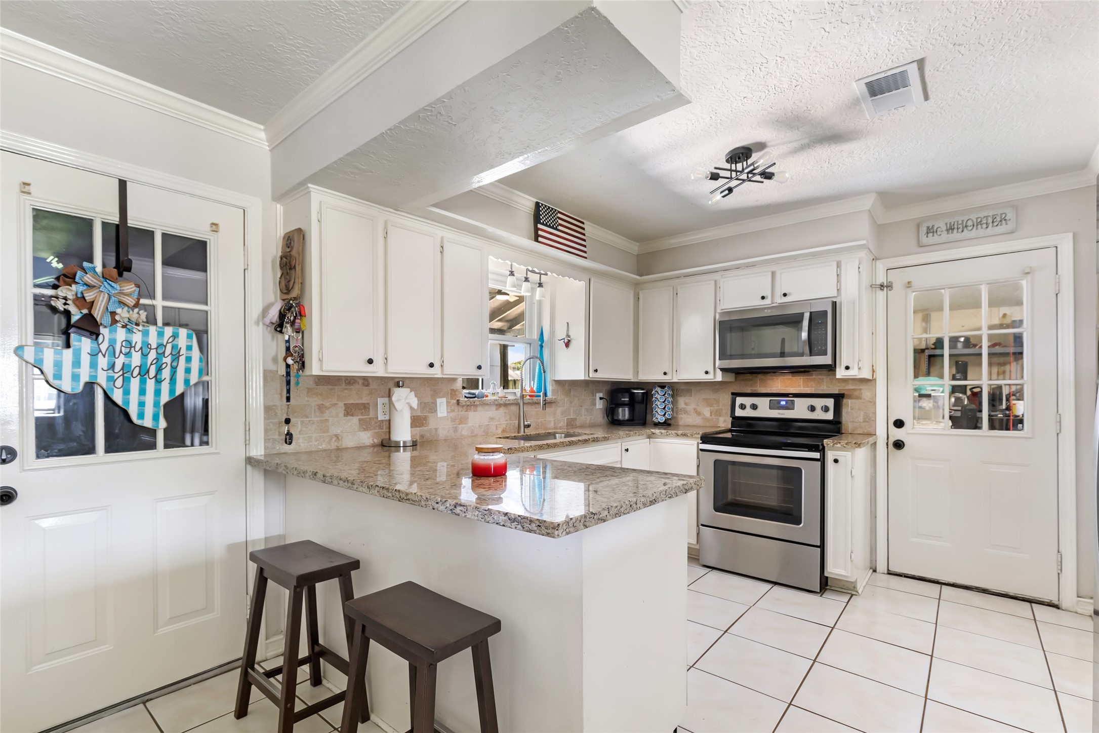 15816 Ramsey Road Crosby, TX 77532 - Photo 14 of 24 a kitchen with kitchen island granite countertop a stove cabinets and chairs