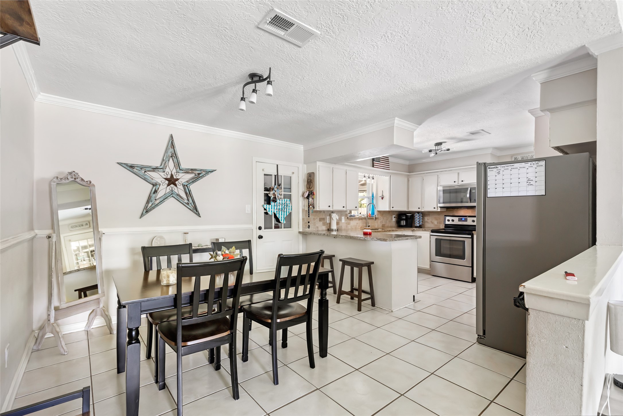 15816 Ramsey Road Crosby, TX 77532 - Photo 16 of 24 a kitchen with kitchen island a dining table chairs and white cabinets