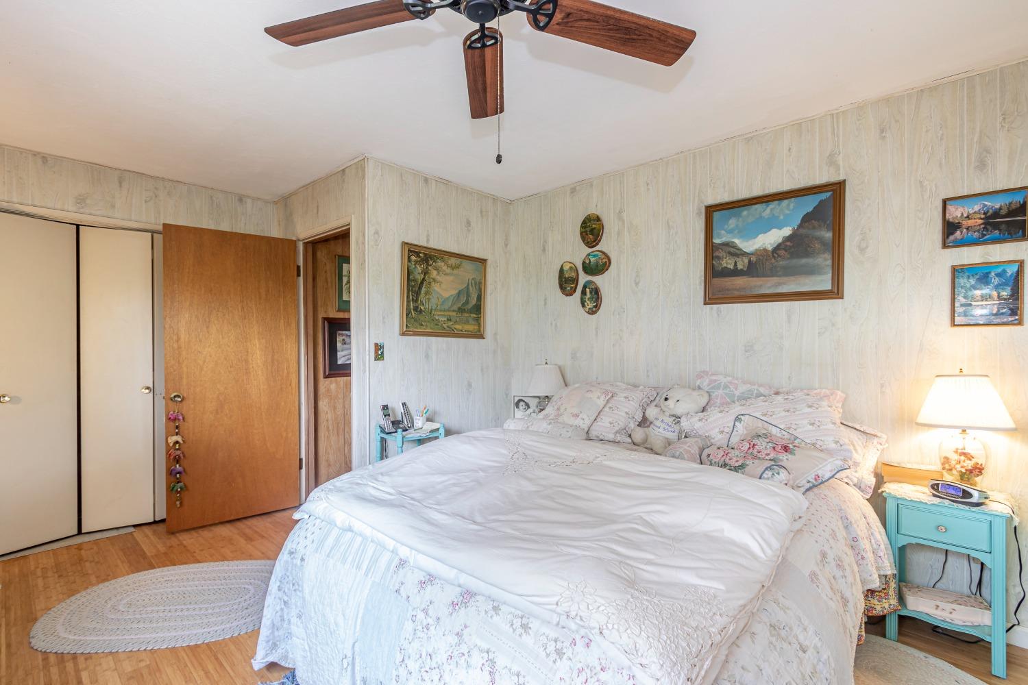 5090 Tiptop Road Mariposa, CA 95338 - Photo 16 of 46 a bedroom with a bed and a chandelier