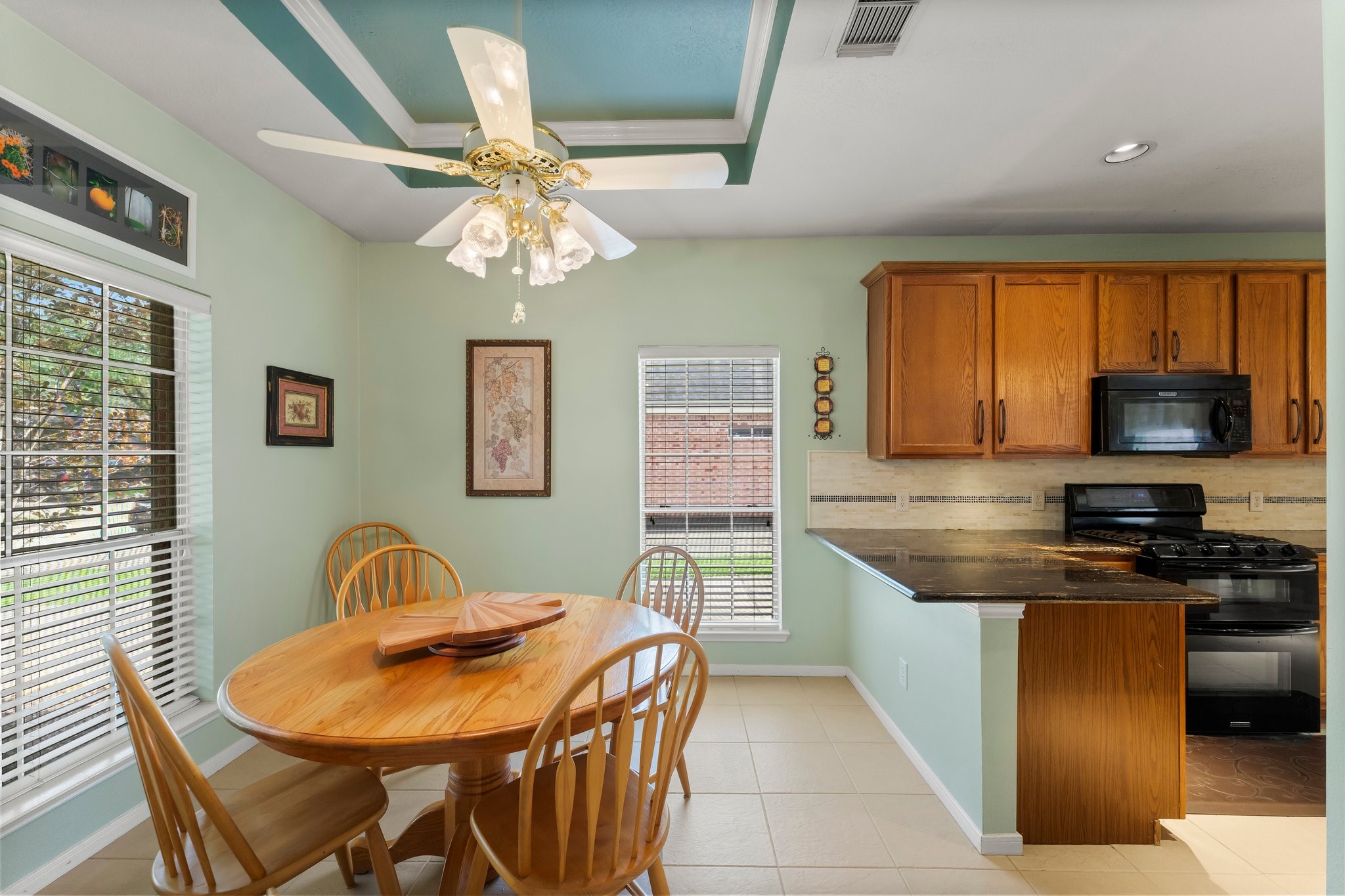 4210 Rainfall Drive Pasadena, TX 77505 - Photo 11 of 46 a kitchen with stainless steel appliances granite countertop a stove a sink a microwave a dining table and chairs with wooden floor