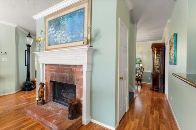a view of a livingroom with wooden floor and a fireplace