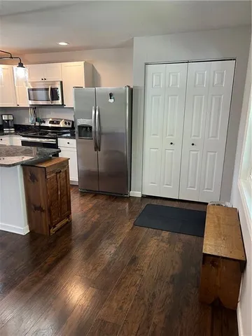 a kitchen with granite countertop a refrigerator and a stove top oven