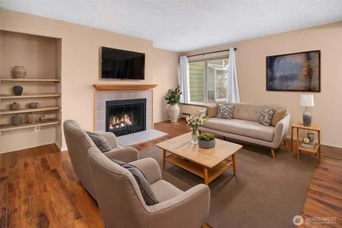 a living room with furniture a flat screen tv and a fireplace