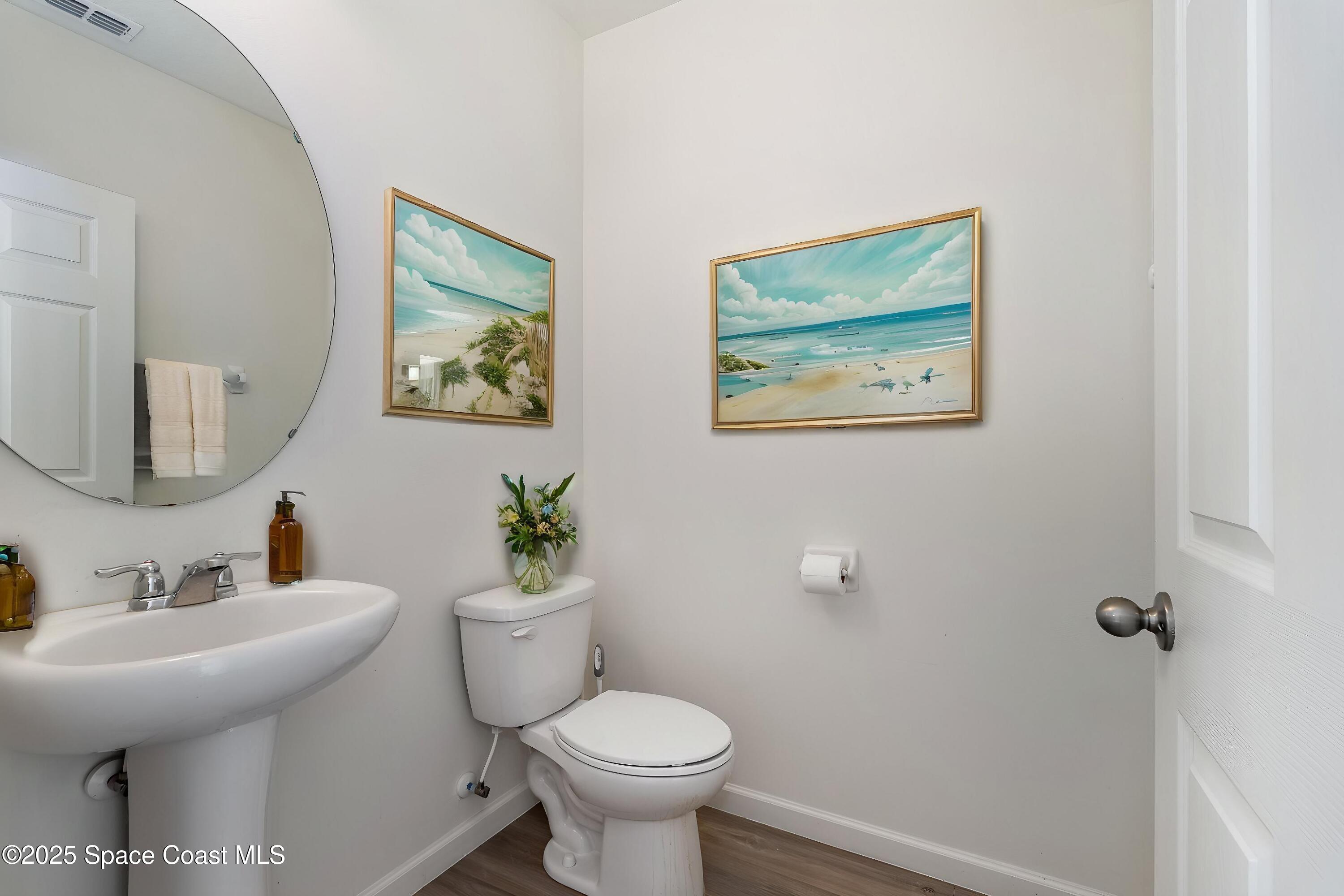 1085 Newton Circle Rockledge, FL 32955 - Photo 15 of 34 a bathroom with a toilet a sink and mirror