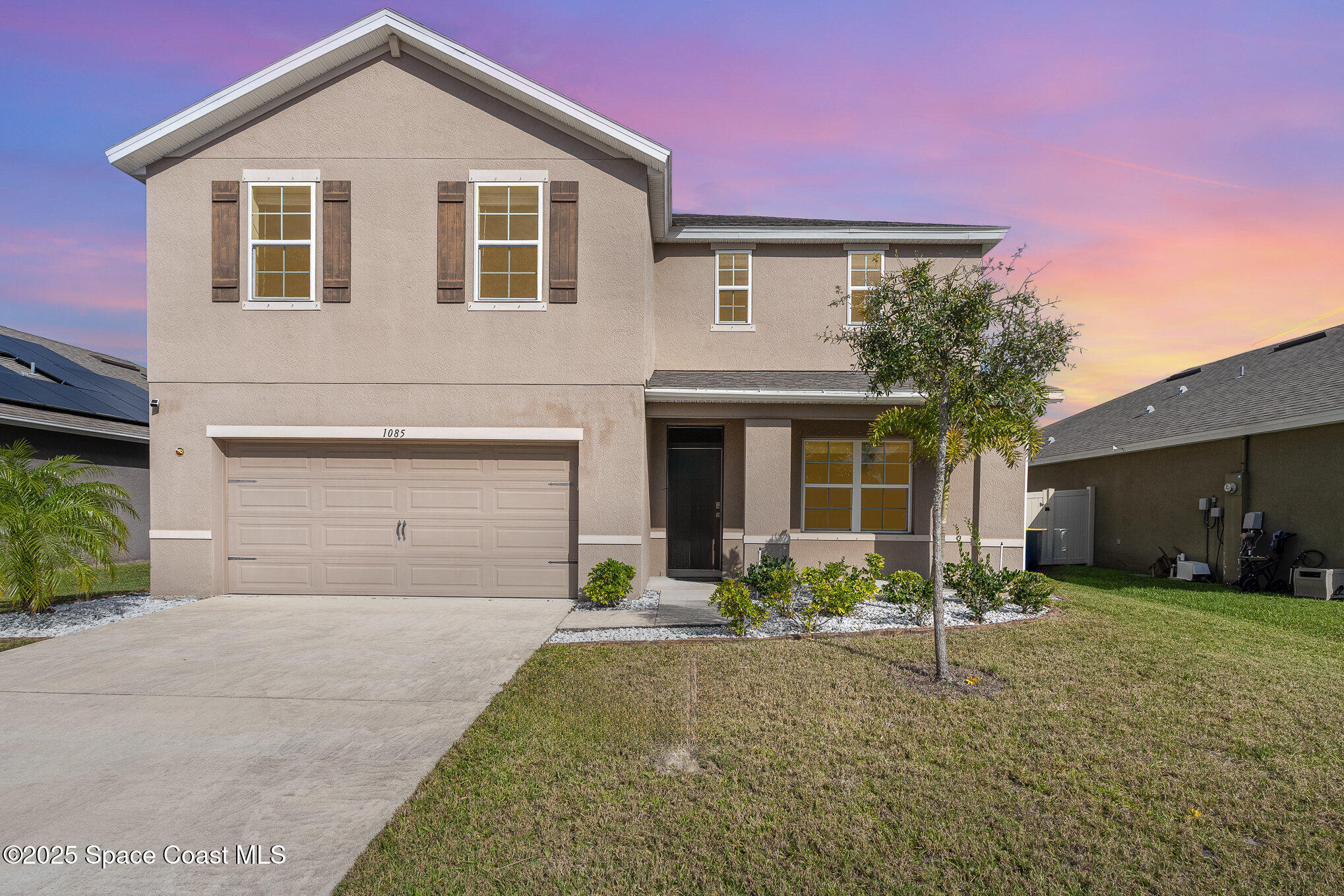 1085 Newton Circle Rockledge, FL 32955 - Photo 2 of 34 a front view of a house with a yard and garage