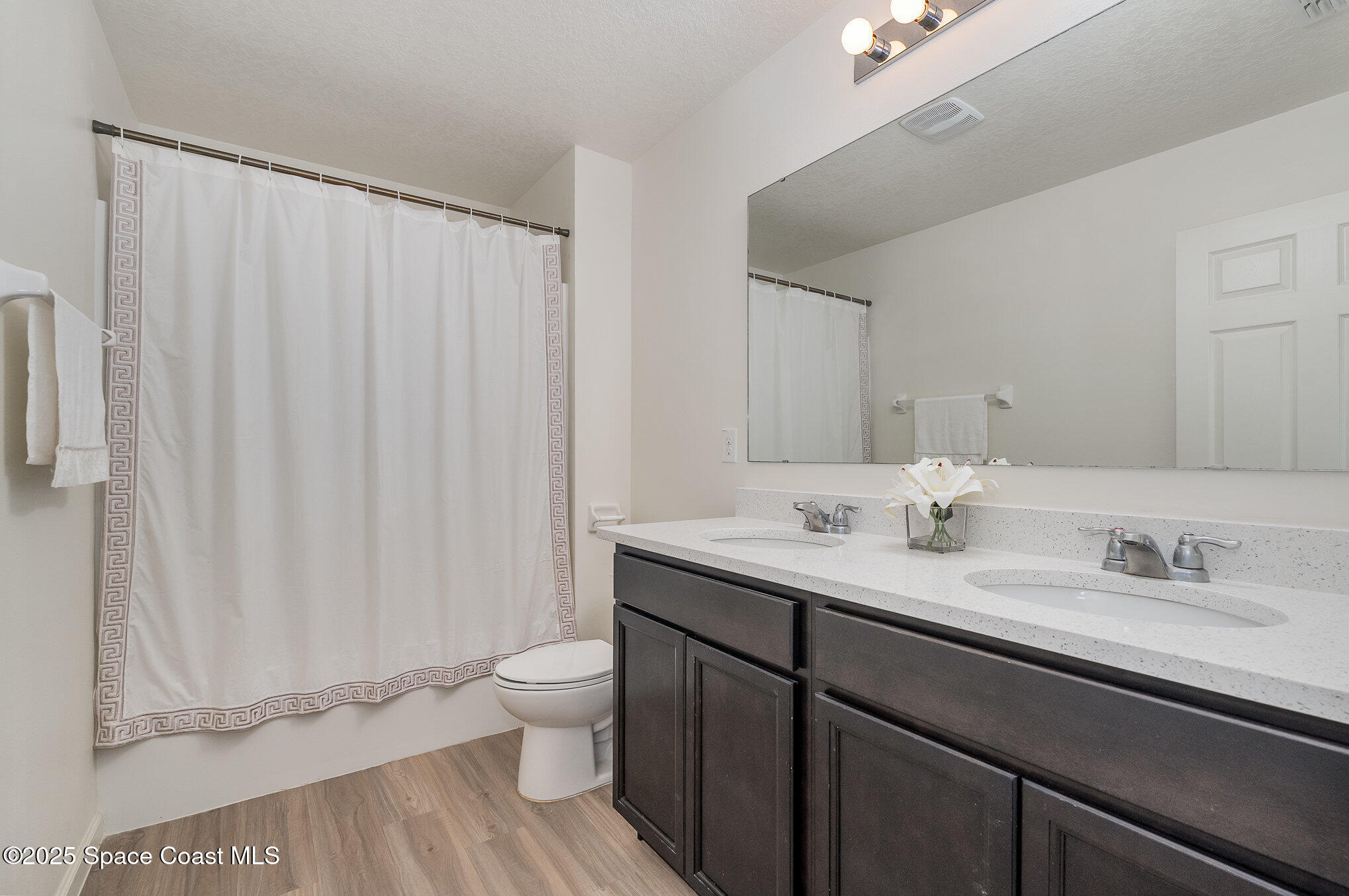 1085 Newton Circle Rockledge, FL 32955 - Photo 24 of 34 a bathroom with a granite countertop sink a toilet and a mirror