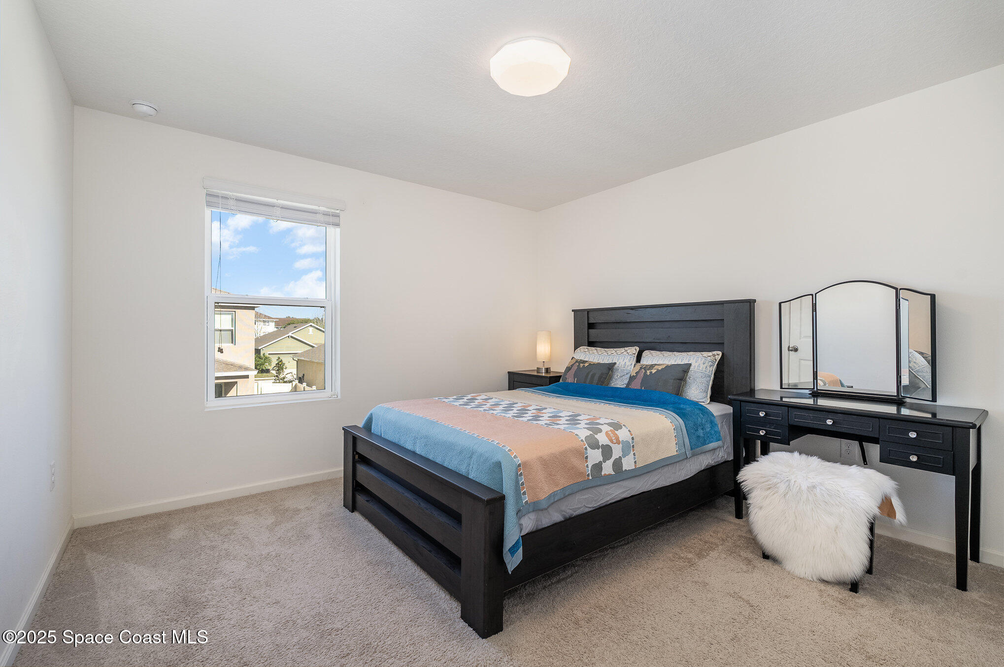 1085 Newton Circle Rockledge, FL 32955 - Photo 27 of 34 a bedroom with a bed lamp and a window