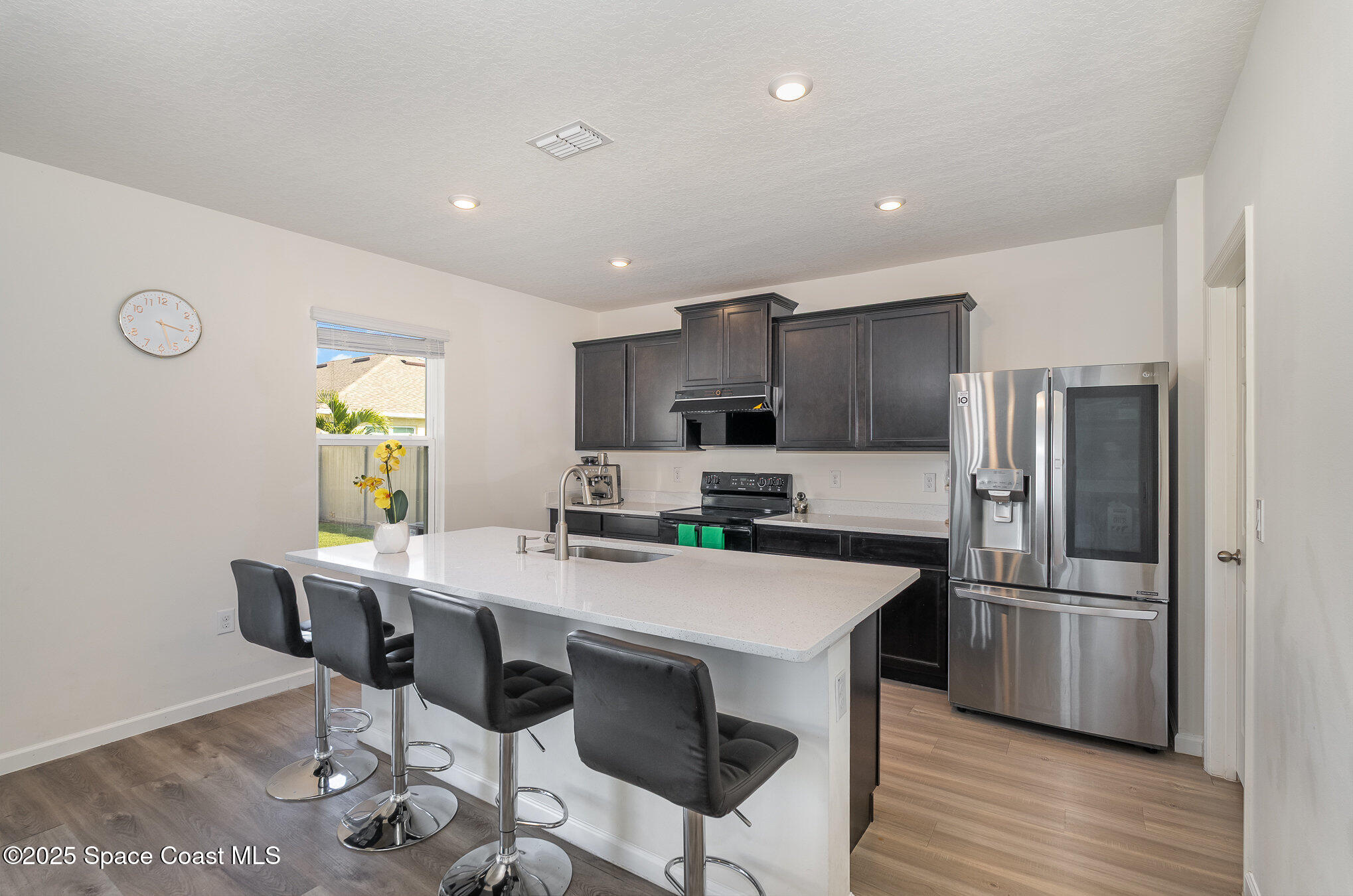 1085 Newton Circle Rockledge, FL 32955 - Photo 3 of 34 a kitchen with stainless steel appliances a table chairs refrigerator and wooden floor
