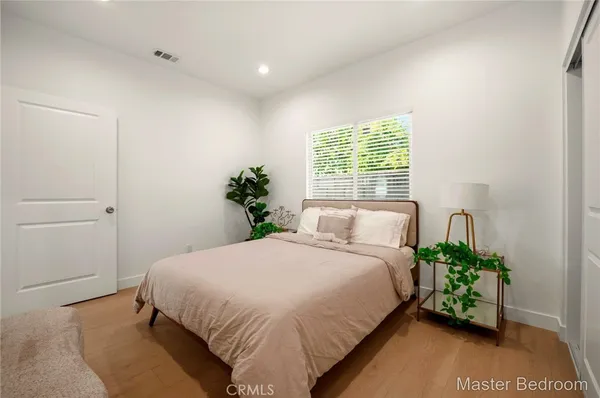 a bedroom with a bed mirror and a potted plant